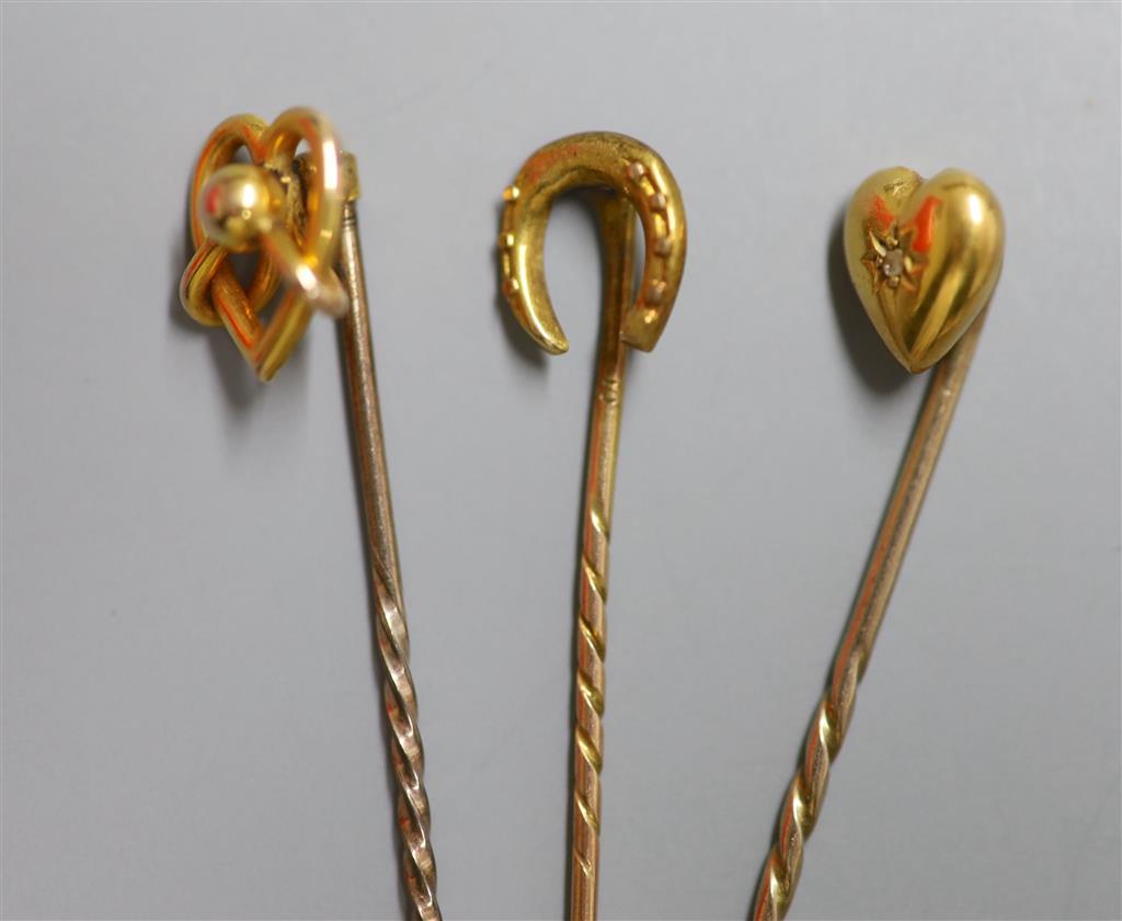 Three assorted Edwardian yellow metal stick pins, one set with diamond chip, 59mm et infra, gross 3.2 grams.